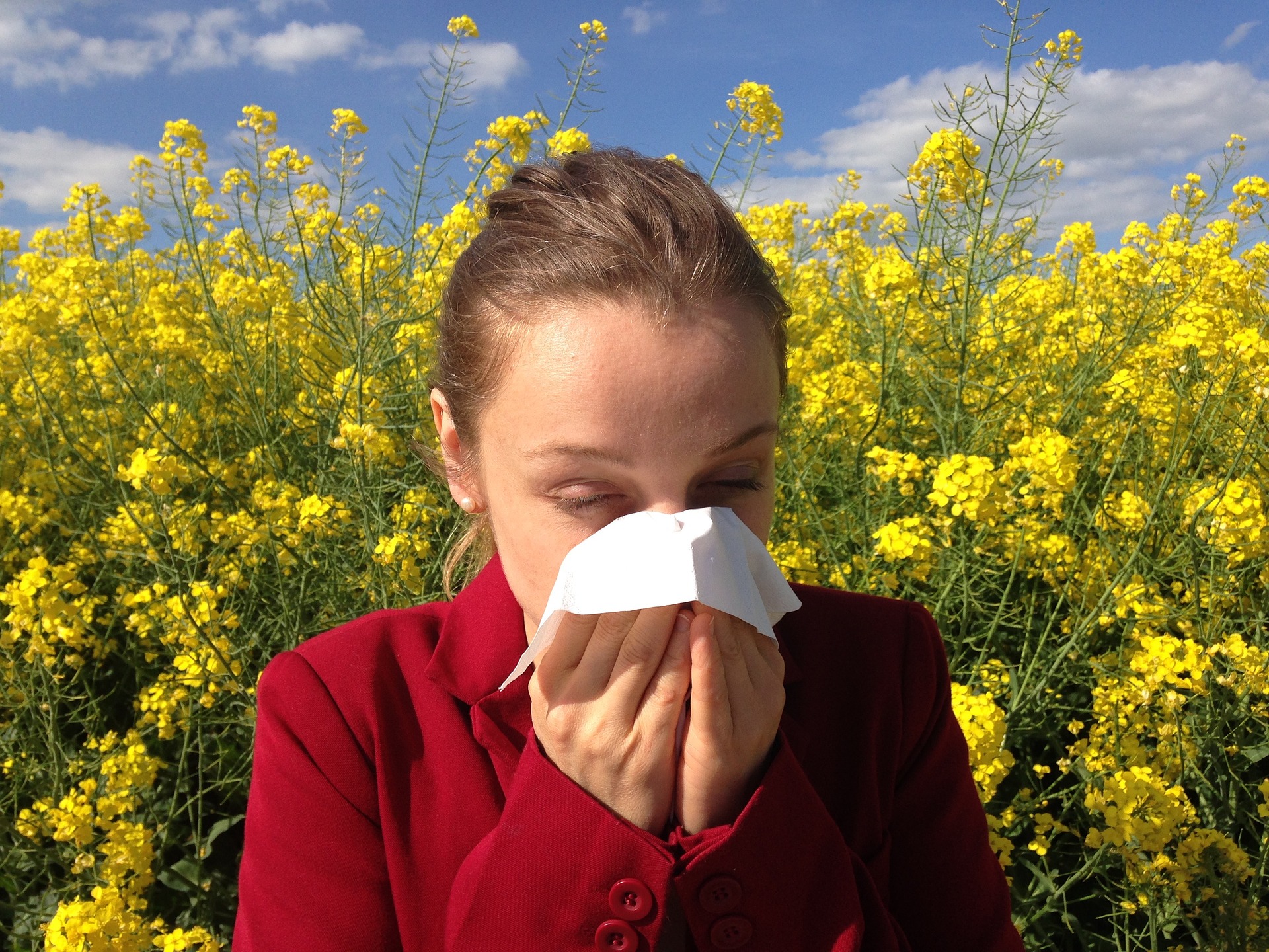 Woman sneezing in a field of flowers